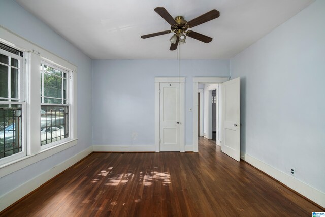 empty room with baseboards, wood finished floors, and a ceiling fan