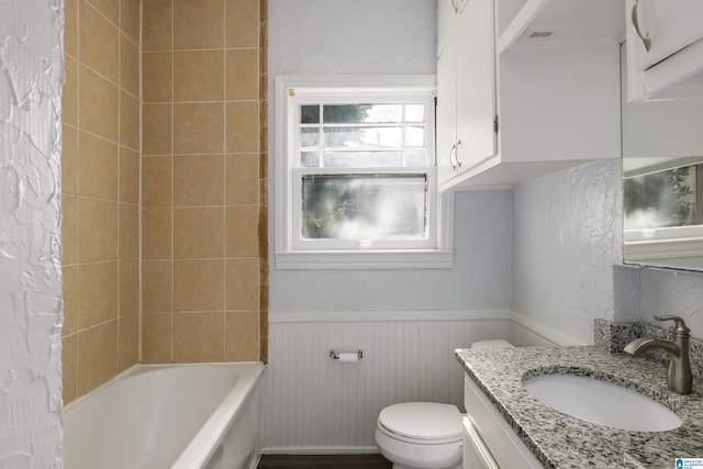 bathroom featuring vanity, shower / bath combination, toilet, and wainscoting