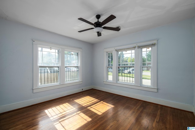 unfurnished room featuring dark wood-type flooring, baseboards, a wealth of natural light, and ceiling fan