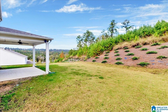 view of yard with ceiling fan and a patio