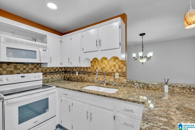 kitchen with white appliances, sink, decorative light fixtures, and white cabinets