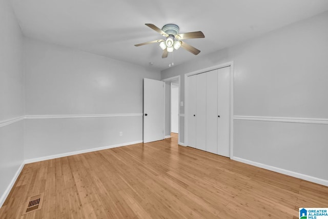 unfurnished bedroom with a closet, light wood-type flooring, and ceiling fan