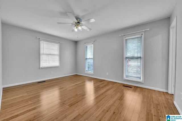 unfurnished room with light hardwood / wood-style flooring, ceiling fan, and a wealth of natural light