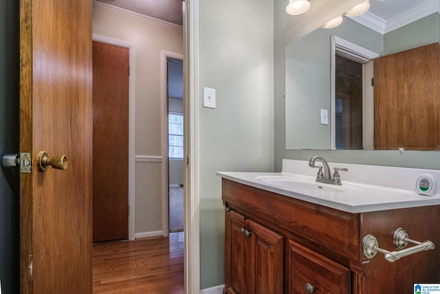 bathroom with vanity, ornamental molding, and hardwood / wood-style flooring