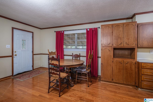 dining area with crown molding, light hardwood / wood-style flooring, and a textured ceiling