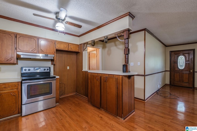 kitchen featuring light hardwood / wood-style flooring, kitchen peninsula, crown molding, a textured ceiling, and stainless steel electric range oven