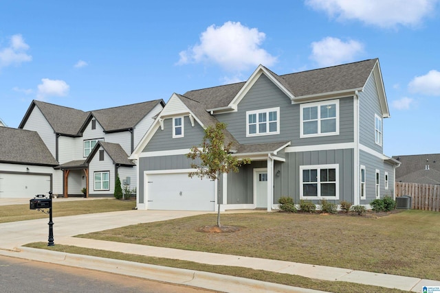 view of front of home featuring cooling unit, a front yard, and a garage