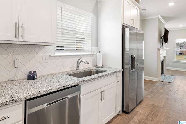 kitchen featuring sink, white cabinetry, stainless steel appliances, and light hardwood / wood-style floors