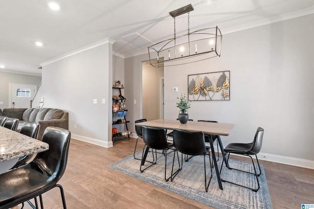 dining space with ornamental molding and hardwood / wood-style floors