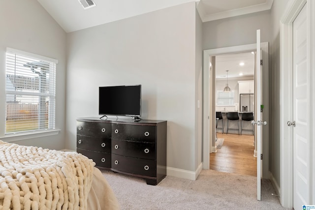 carpeted bedroom with lofted ceiling and stainless steel refrigerator with ice dispenser