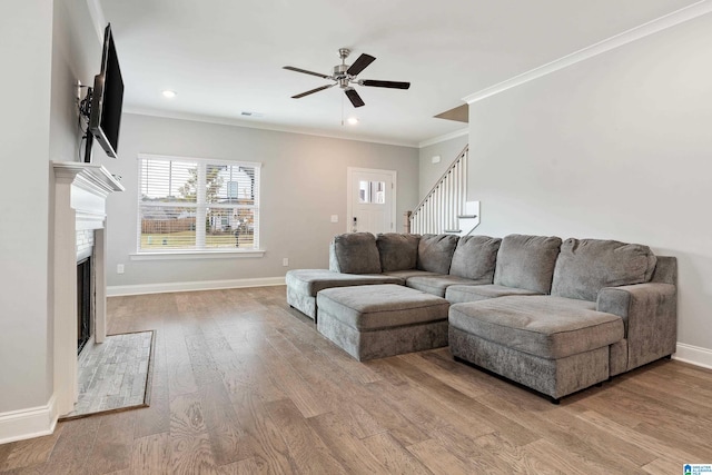 living room with ornamental molding, hardwood / wood-style flooring, and ceiling fan