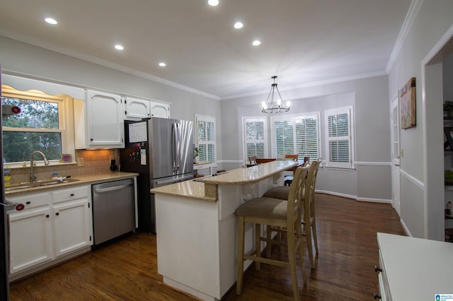 kitchen with white cabinets, plenty of natural light, pendant lighting, and appliances with stainless steel finishes