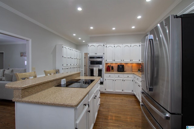 kitchen with stainless steel appliances, ornamental molding, a kitchen breakfast bar, dark hardwood / wood-style floors, and white cabinets