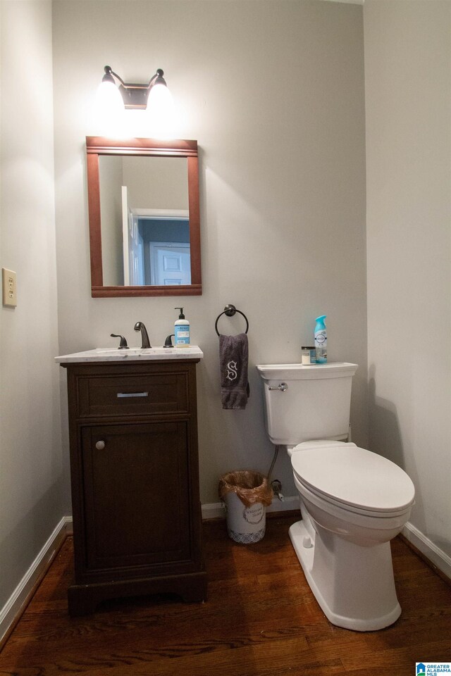 bathroom featuring wood-type flooring, vanity, and toilet