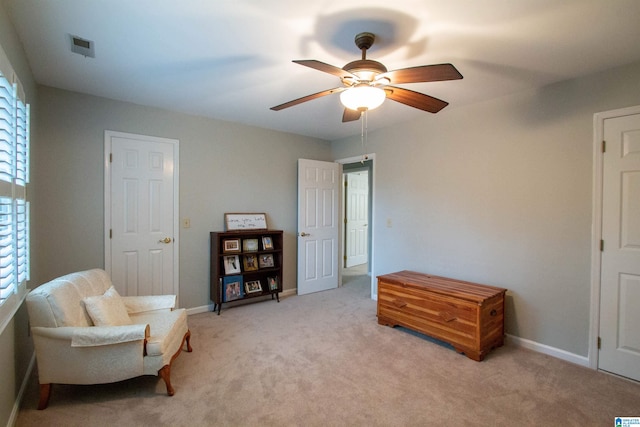 sitting room featuring ceiling fan and light colored carpet