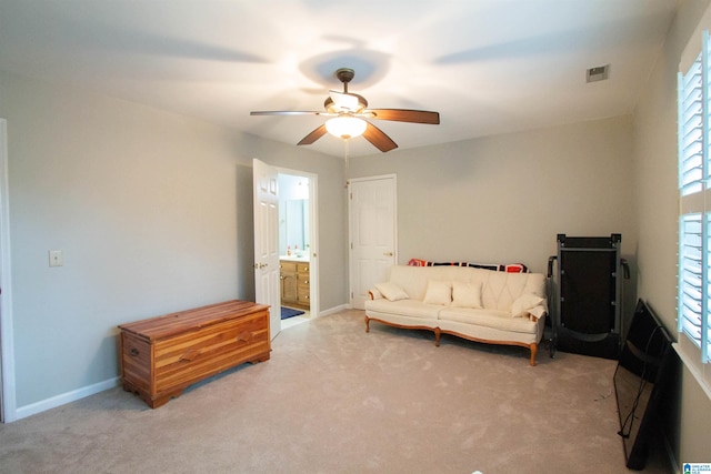 living area with light carpet and ceiling fan