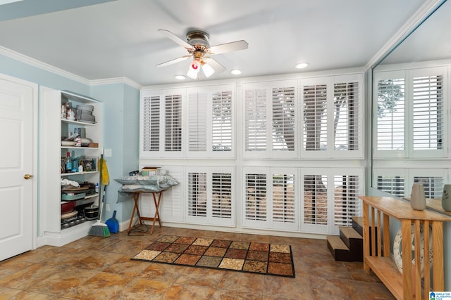 interior space with ceiling fan and crown molding