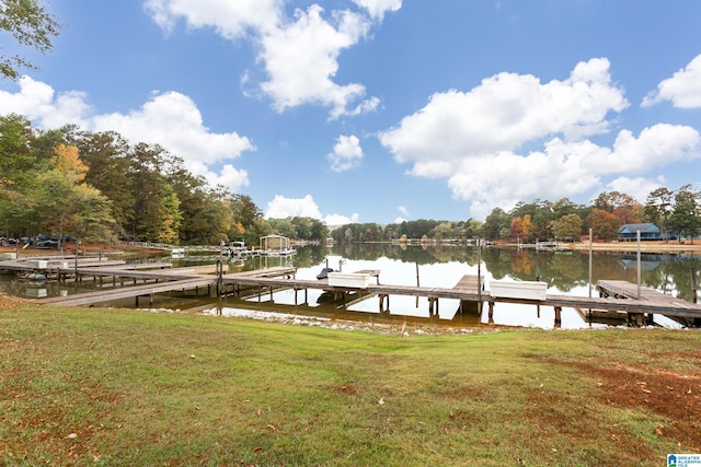 view of dock featuring a lawn and a water view