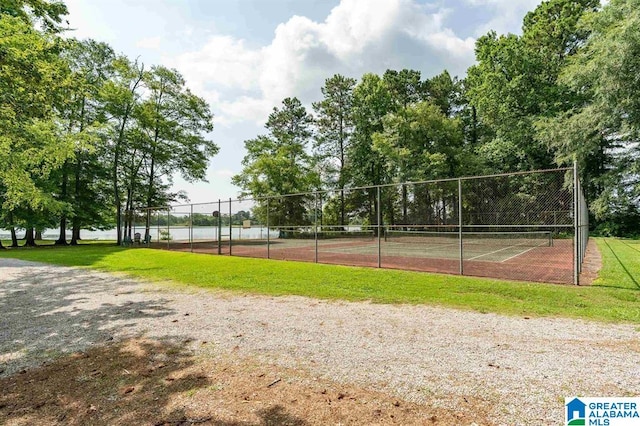 view of community with tennis court and a lawn