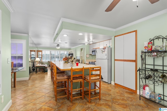 dining area featuring ceiling fan and crown molding