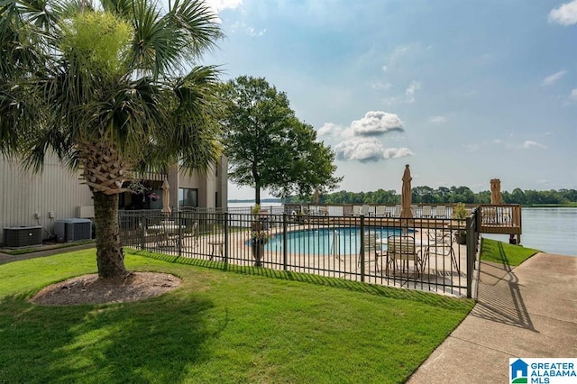 view of swimming pool with a water view, cooling unit, and a yard