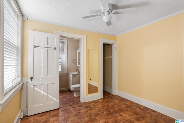 unfurnished bedroom featuring sink, ceiling fan, connected bathroom, ornamental molding, and a textured ceiling