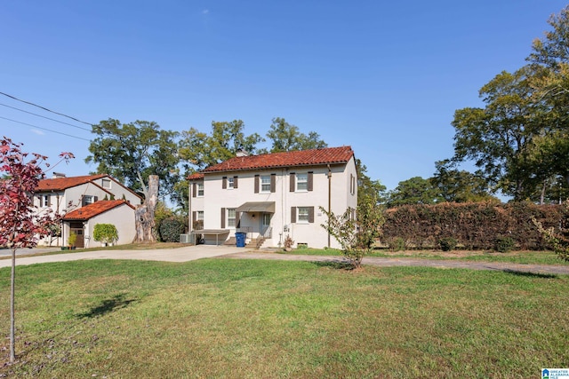 mediterranean / spanish home featuring central AC unit and a front lawn