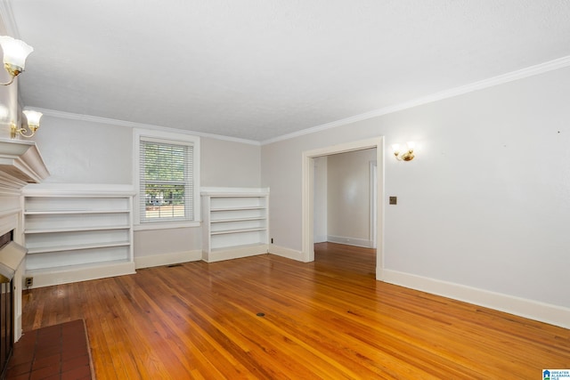 unfurnished living room featuring crown molding, hardwood / wood-style flooring, and a chandelier