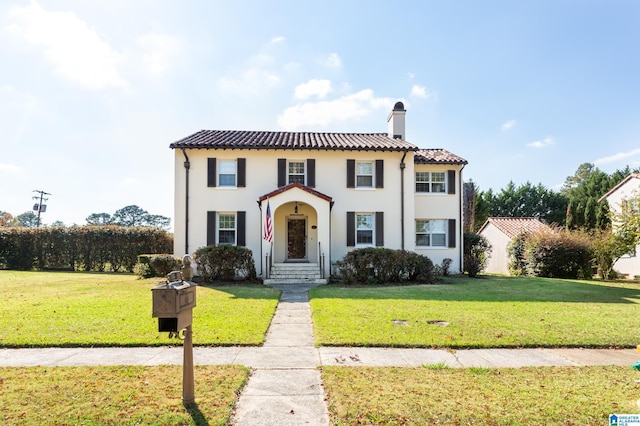 mediterranean / spanish home with a front lawn