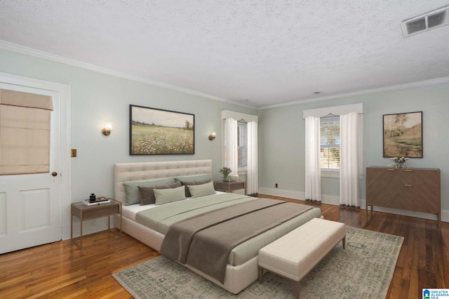 bedroom with crown molding, hardwood / wood-style floors, and a textured ceiling