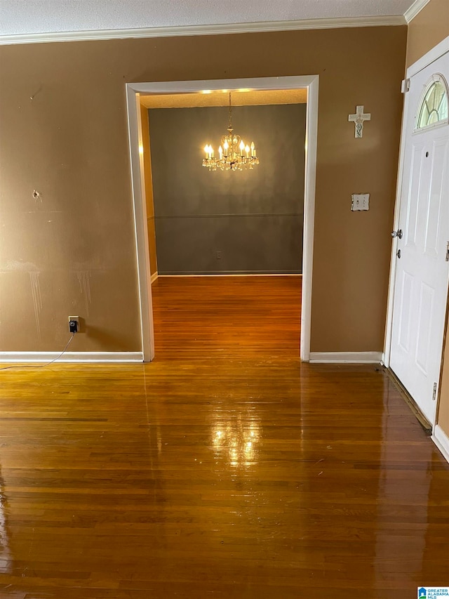 interior space with a chandelier, crown molding, dark hardwood / wood-style floors, and a textured ceiling