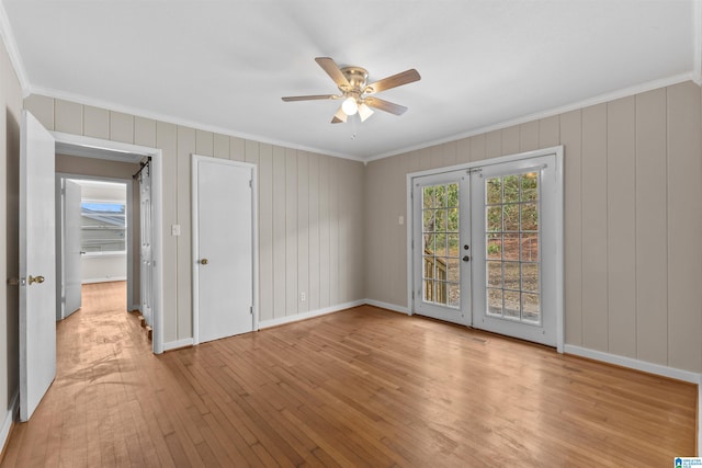 empty room featuring light hardwood / wood-style floors, french doors, and ornamental molding