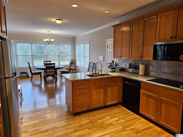 kitchen featuring light hardwood / wood-style floors, black appliances, sink, and kitchen peninsula