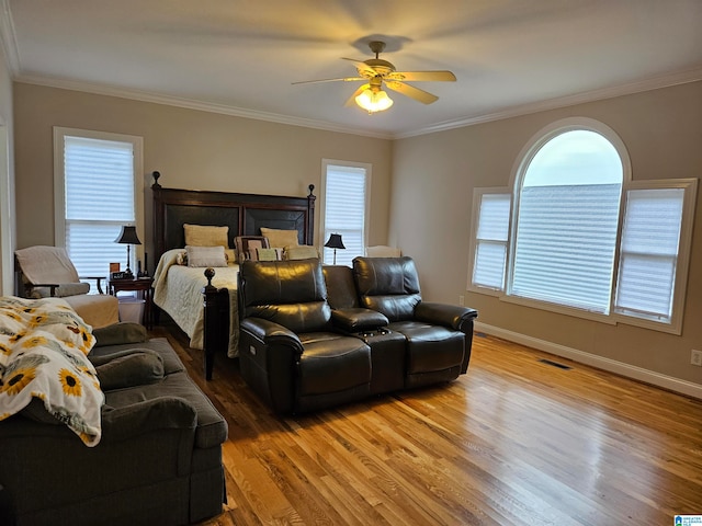 bedroom with ornamental molding, hardwood / wood-style floors, and ceiling fan