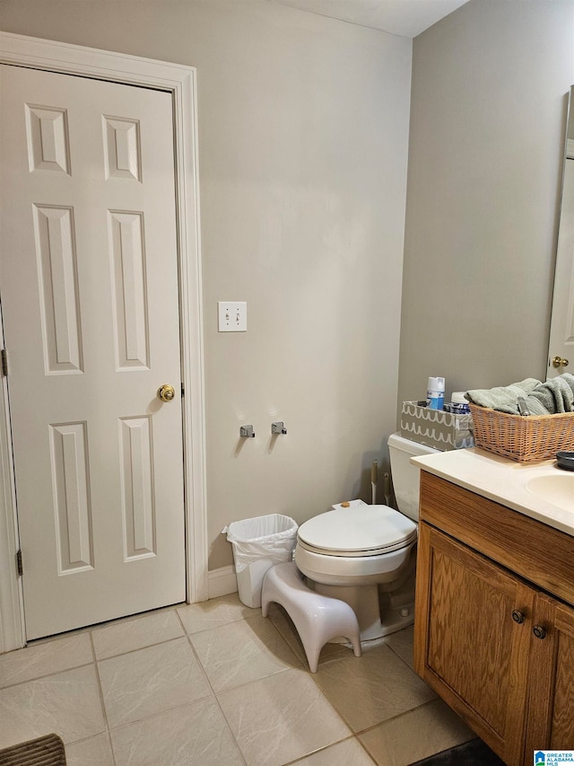 bathroom featuring toilet, vanity, and tile patterned floors