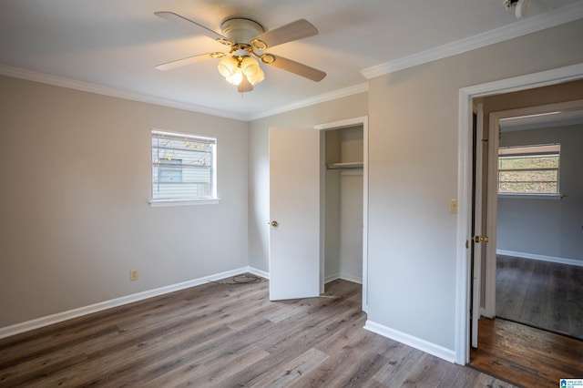 unfurnished bedroom featuring multiple windows, ceiling fan, and wood-type flooring