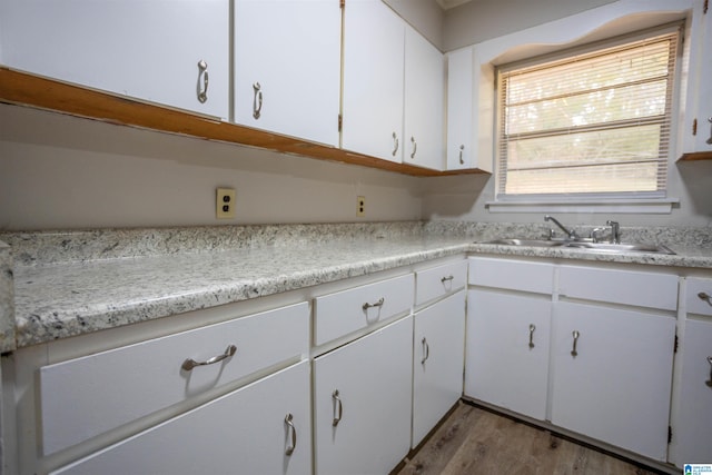 kitchen featuring white cabinetry, sink, and light hardwood / wood-style flooring