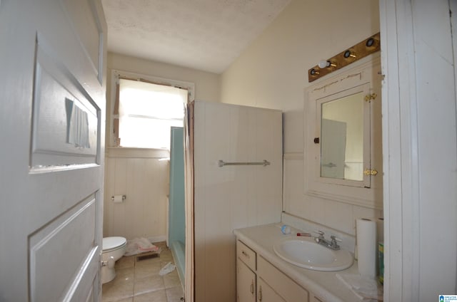 bathroom with a textured ceiling, toilet, tile patterned floors, walk in shower, and vanity