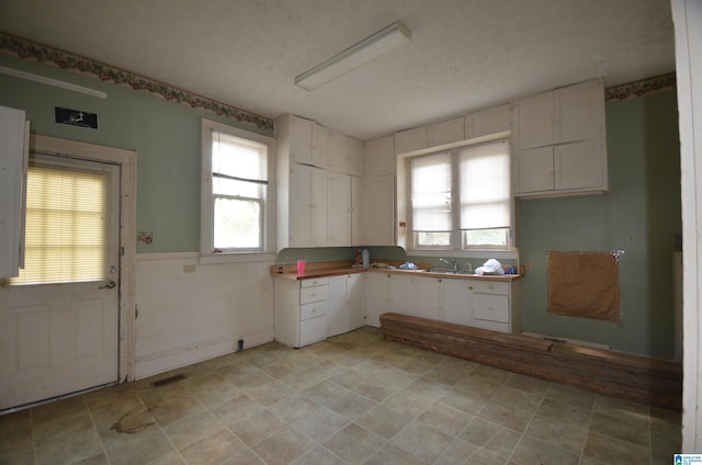 kitchen featuring white cabinetry, sink, and a textured ceiling