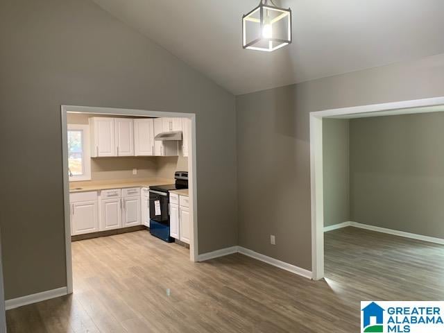 kitchen featuring black electric range oven, white cabinets, high vaulted ceiling, pendant lighting, and light hardwood / wood-style floors