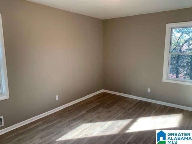 empty room with dark hardwood / wood-style flooring