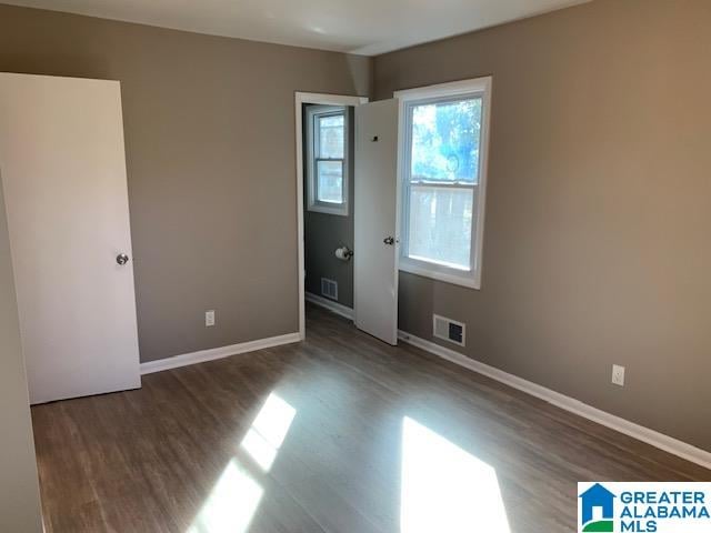 unfurnished bedroom with dark wood-type flooring