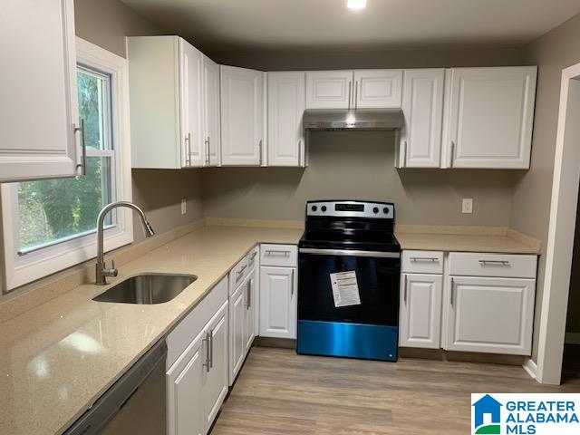 kitchen featuring appliances with stainless steel finishes, plenty of natural light, and white cabinets