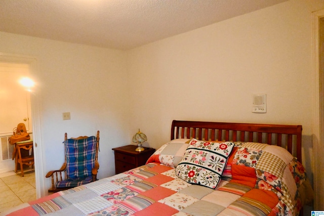 bedroom featuring a textured ceiling and tile patterned floors