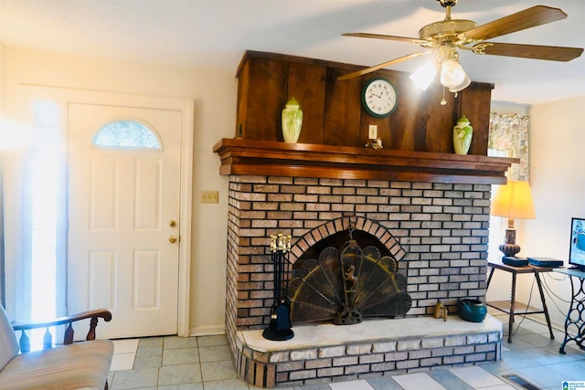 interior details featuring ceiling fan, a brick fireplace, and tile patterned flooring