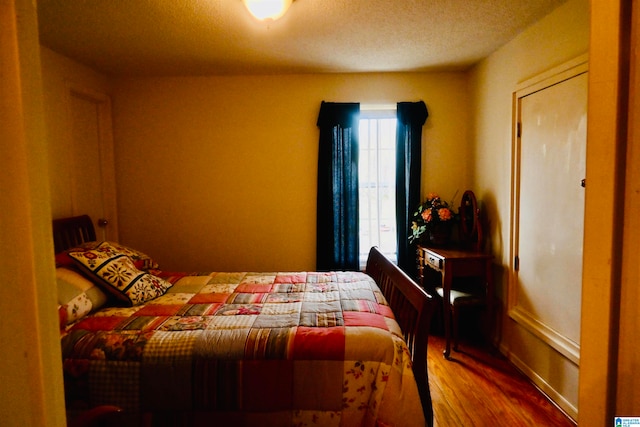 bedroom featuring wood-type flooring and a textured ceiling