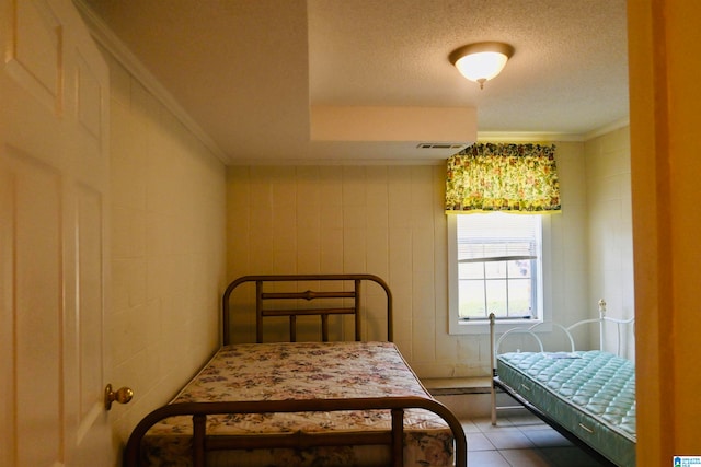 tiled bedroom with crown molding and a textured ceiling