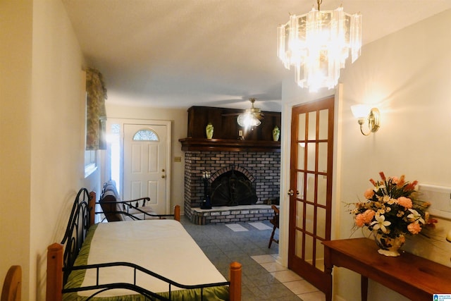 477 County Road 183, Eutaw, AL 35462 - living area featuring a brick fireplace, ceiling fan, tile patterned floors, and a chandelier