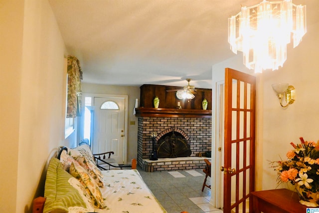 living room featuring a fireplace, ceiling fan with notable chandelier, and light tile patterned floors