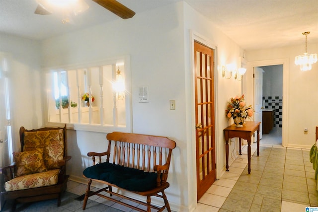 sitting room featuring light tile patterned floors and ceiling fan with notable chandelier